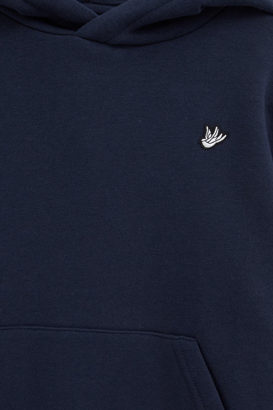 Close-up van een donkerblauwe hoodie met een witte vogelembroidery op de linkerborst en een kangoeroezak.