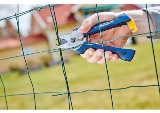 Hand met een blauwe Rapid FP20 hekwerktang die groen draad van een hekwerk knipt. Gele grijper aan de onderkant.