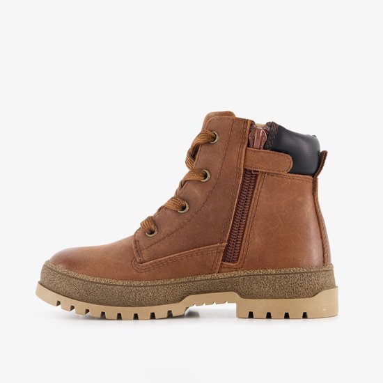 Bruine leren veterschoen met zijrits en zwarte kraag op een beige profielzool.