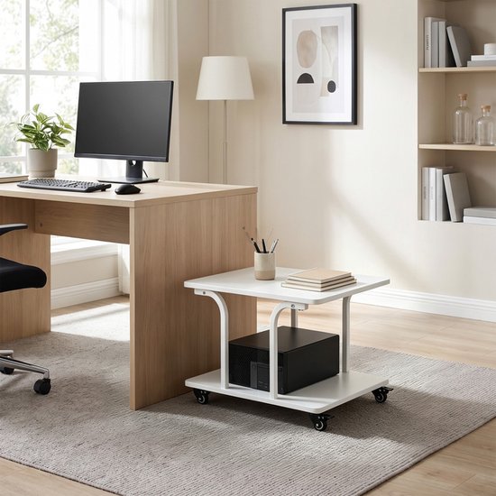 Witte roltafel met twee niveaus, met een computerkast en boeken erop, naast een bureau met monitor.