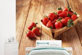 Un bol plein de fraises sur une table en bois clair Papier peint photo vinyle largeur 265 cm x hauteur 220 cm - Tirage photo sur papier peint (disponible en 7 tailles)