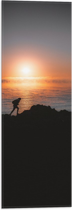 WallClassics - Vlag - Man lopend over Berg aan de Zee met Zonsondergang - 20x60 cm Foto op Polyester Vlag