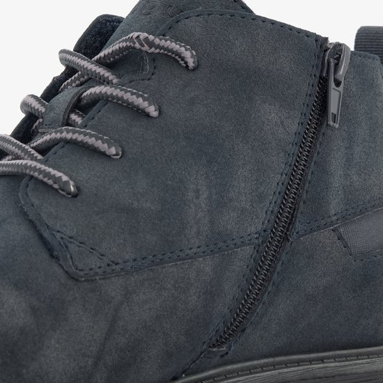 Close-up van een donkerblauwe suède veterschoen met ritssluiting en grijze veters.