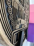 Goudkleurige Bitcoin-munt met gedetailleerd circuitpatroon en kleine cirkelvormige details.