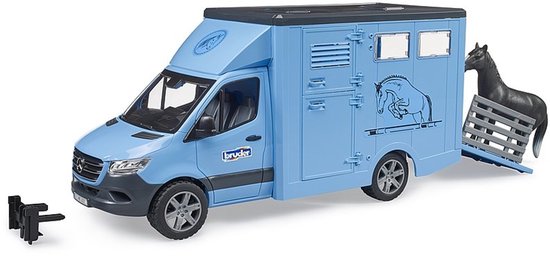 Lichtblauwe Bruder paardenwagen met een paard ernaast en een trekhaakje. Dewagen heeft een afbeelding van een springend paard.