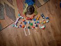 Enfants jouant avec des pièces Duplo F1 sur un plancher en bois