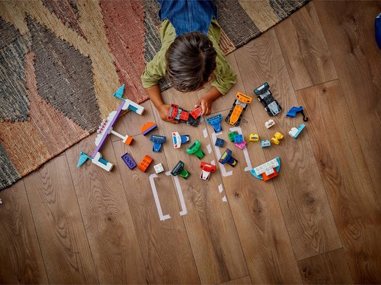 Enfants jouant avec des pièces Duplo F1 sur un plancher en bois