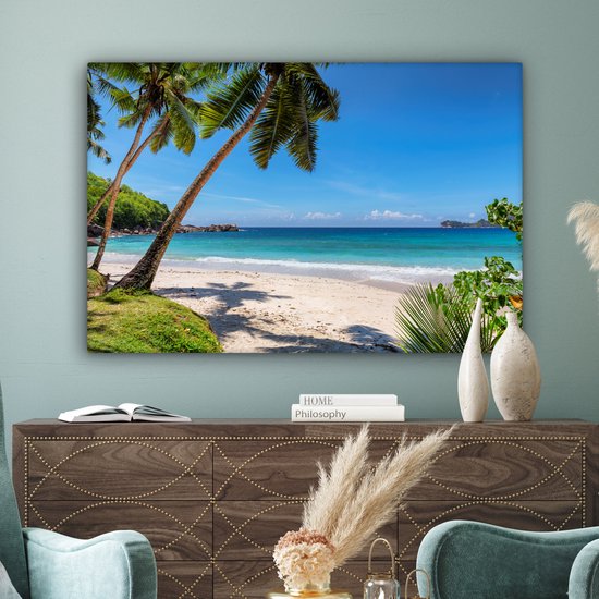 Une plage tropicale avec du sable blanc, des palmiers et une mer d'azur.