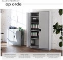 Grijze archiefkast met open deuren, gevuld met mappen en een kluisje. Links staat een kleinere grijze kast.