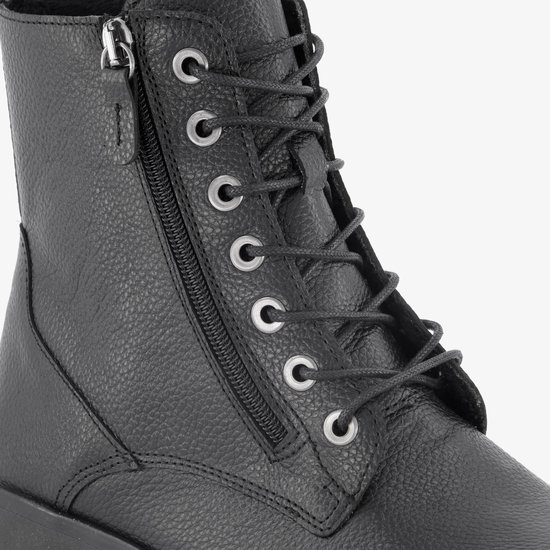 Detail van de veter en rits van een zwarte leren veterboot.