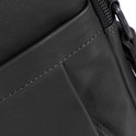 Detail van de stiksels op een zwarte leren tas met een steekvak.