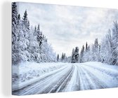 Canvas Schilderij Een besneeuwde weg wat omringt is door een winterlandschap - 90x60 cm - Wanddecoratie