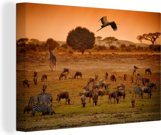 Foto: Canvas schilderij gnoes staan te grazen tussen de andere wilde dieren in kenya 90x60 cm wanddecoratie