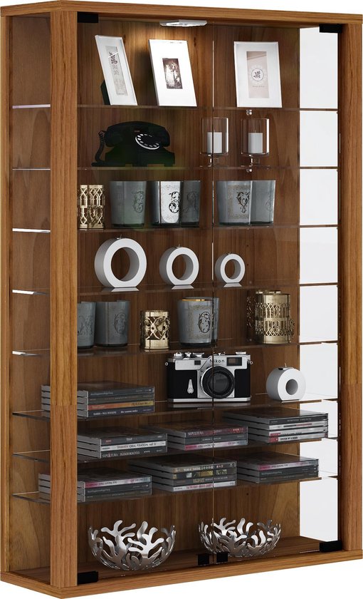 Houten vitrinekast met glazen deuren, gevuld met fotolijsten, een telefoon, decoraties, een camera en boeken.