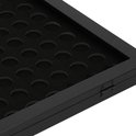 Detail van zwarte lijst, scharnier en cirkelvormige uitsparingen voor capsules.