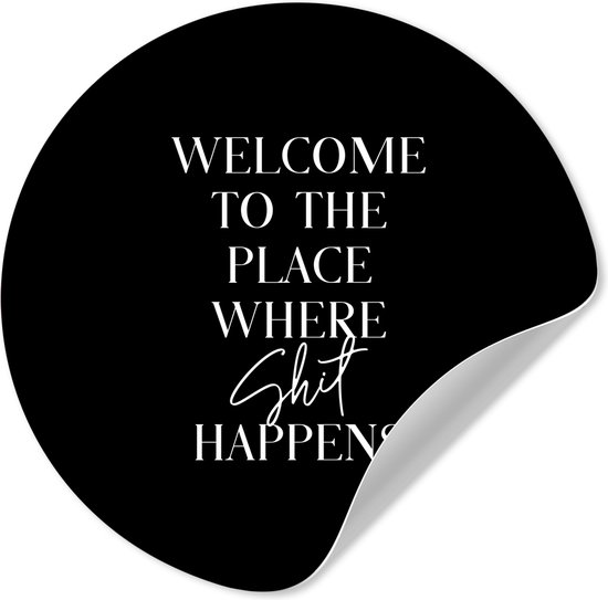Zwarte ronde sticker met witte tekst "WELCOME TO THE PLACE WHERE Shit HAPPENS". Een hoek is omgeslagen.