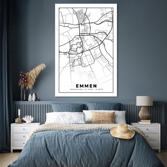 Affiche carte d'Emmen en noir et blanc, au-dessus d'un lit avec linge de lit bleu.