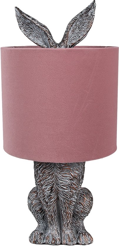 Lampe de table avec un pied de lapin brun et un abat-jour rose. Les oreilles du lapin dépassent de l'abat-jour.