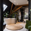 Rond jute vloerkleed met een diameter van 240 cm in een natuurlijke kleur, geplaatst in een badkamer met een vrijstaand bad.