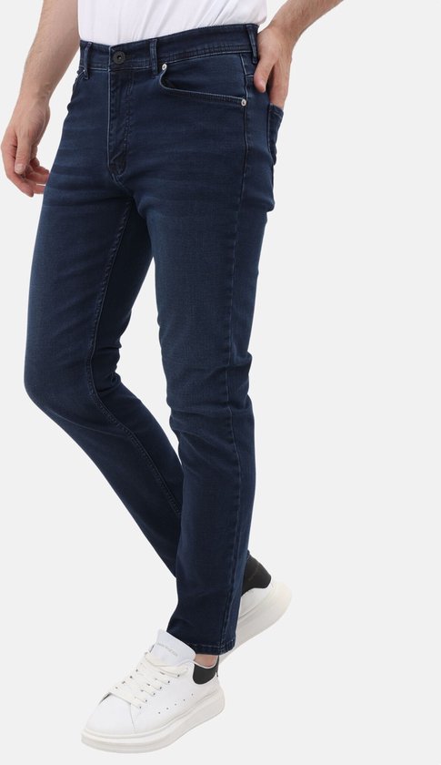 Blauwe stretch jeans met regular fit voor heren. Gedragen met witte sneakers.