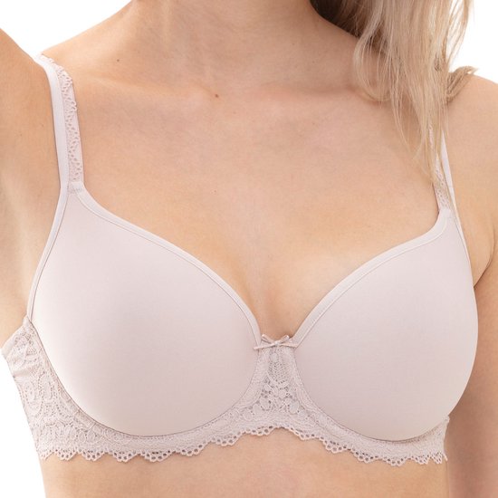 Gros plan sur les bonnets d'un soutien-gorge beige, ornés d'un petit nœud et d'une finition en dentelle.