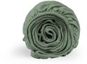 Drap-housse vert passé enroulé, détail de la texture et de l'élastique.