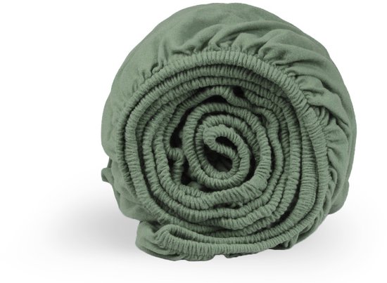 Drap-housse vert passé enroulé, détail de la texture et de l'élastique.