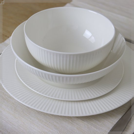 Witte OTIX kommen en borden op een placemat, met een ribbelpatroon.