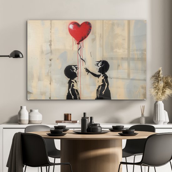 Peinture noir et blanc de deux enfants en silhouette tendant la main vers un ballon rouge en forme de cœur, au-dessus d'une table à manger.