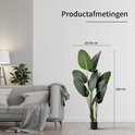 Groene Strelitzia kunstplant, 160 cm hoog en 80-90 cm breed, naast een bank.