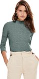 Model van voren gezien, effen groene top met rolkraag, ruches aan de zoom en manchetten en beige broek.