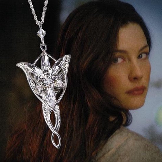 Zilverkleurige Arwen Evenstar hanger met sprankelende kristallen, gedragen door een vrouw met lang bruin haar.