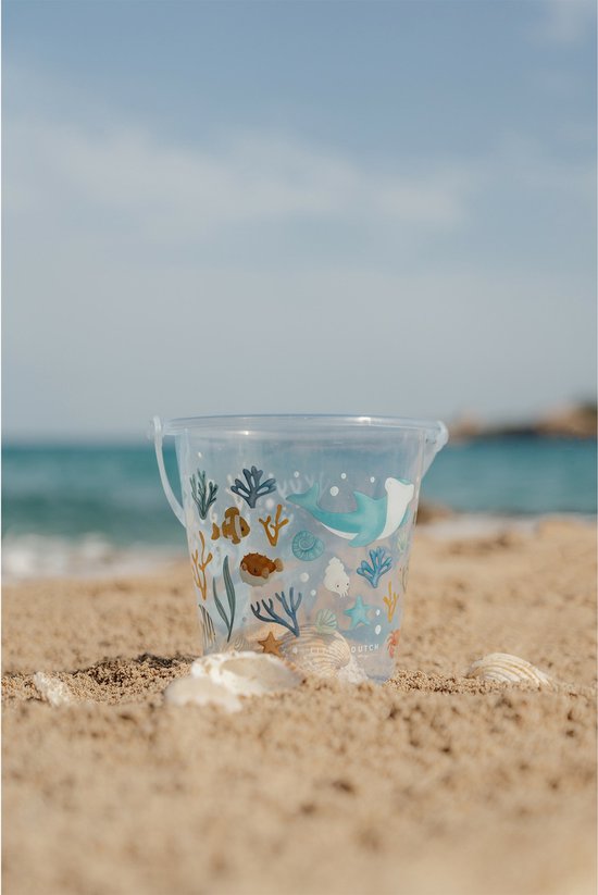 Lichtblauwe emmer met zeelevenprint op het strand.