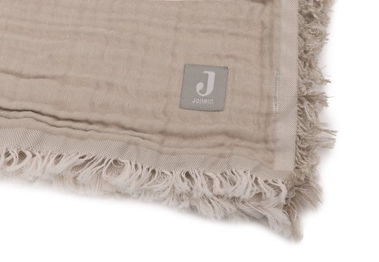 Label 'Jollein' op een lichtbruine mousseline deken met rafels.