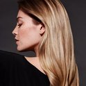 Profil d'une femme aux cheveux longs et blonds, avec des taches de rousseur.