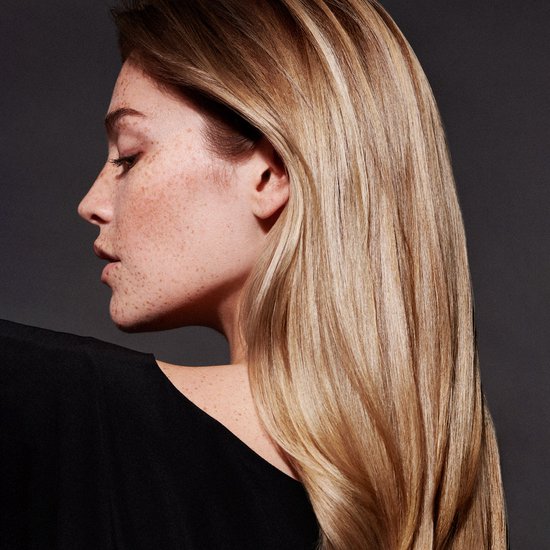 Profil d'une femme aux cheveux longs et blonds, avec des taches de rousseur.