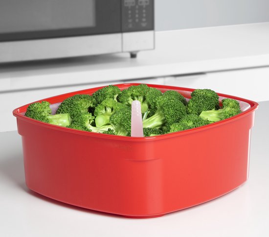 Cuisiseur vapeur rouge rempli de brocoli frais, avec une tige de cuisson rose.