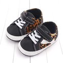 Zwart met luipaardprint babysneakers met klittenbandsluiting en witte veters.