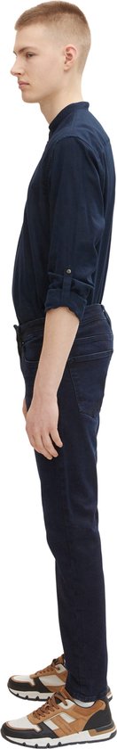 Een man met een donkerblauw overhemd draagt een donkerblauwe jeans.
