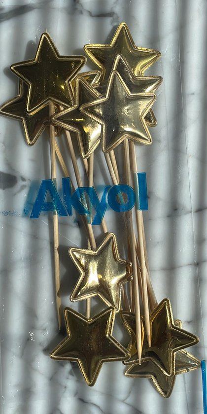 Gouden ster vormige decoratieprikkers met houten stokjes.