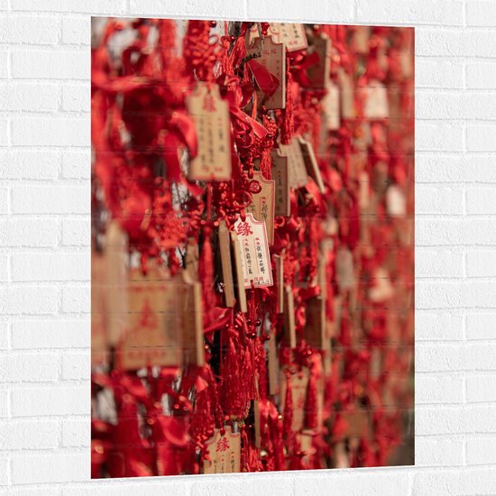 Muursticker - Rode Sleutelhangers met Chinese Tekens aan een Muur - 70x105 cm Foto op Muursticker