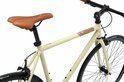 Detail van de crèmekleurige damesfiets: bruin zadel, bruine handvatten, middenframe met logo.