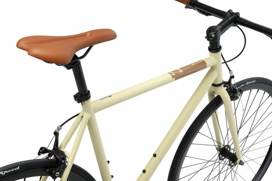 Detail van de crèmekleurige damesfiets: bruin zadel, bruine handvatten, middenframe met logo.