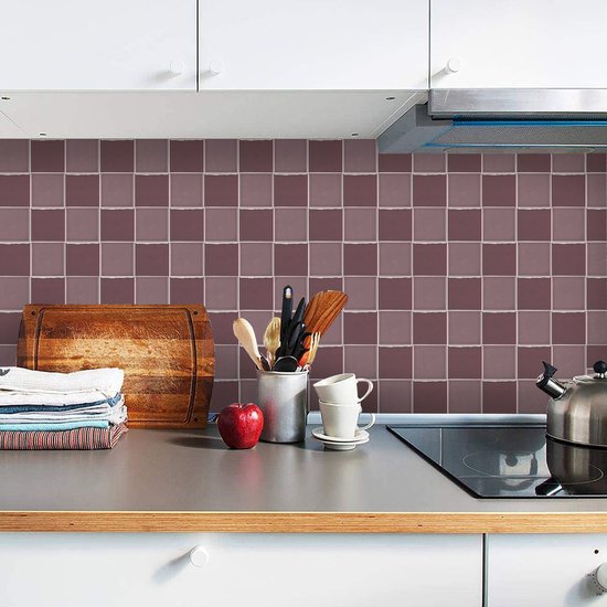Cuisine avec des carreaux lilas et violets comme crédence, une plaque à induction et un plan de travail en bois.