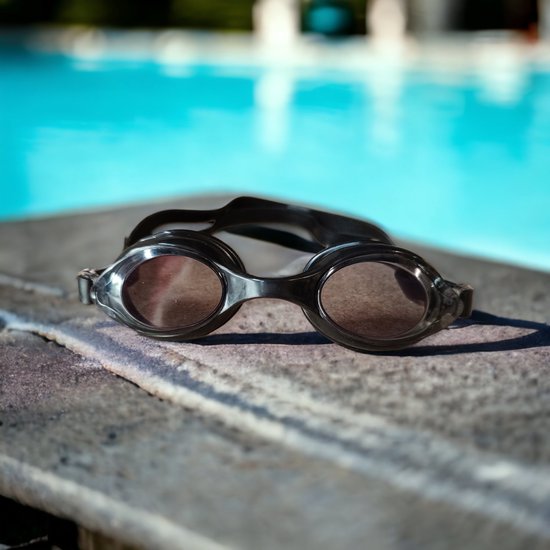 Lunettes de natation noires avec verres teintés sur le bord d'une piscine.