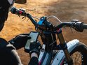 Motorrijder met handschoenen gebruikt telefoon op Quad Lock stuurbevestiging.