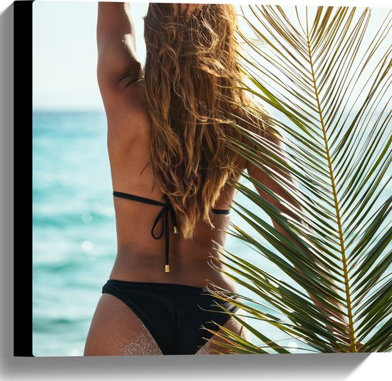 Canvas - Achteraanzicht van Vrouw in Bikini aan Zee met Palmblad - 40x40 cm Foto op Canvas Schilderij (Wanddecoratie op Canvas)