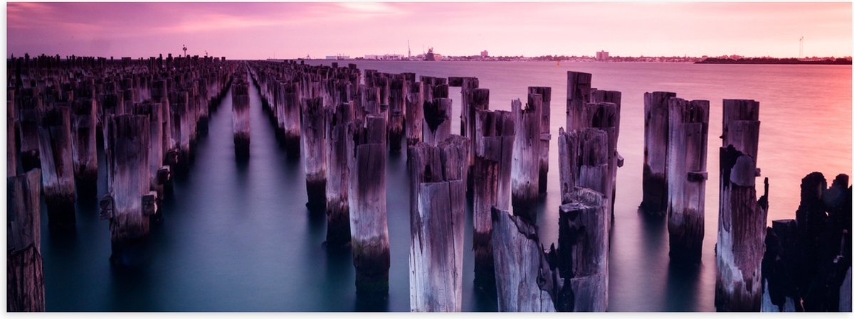 Poster Glanzend – Palen - Water - Hout - Zee - Kleuren - 60x20 cm Foto op Posterpapier met