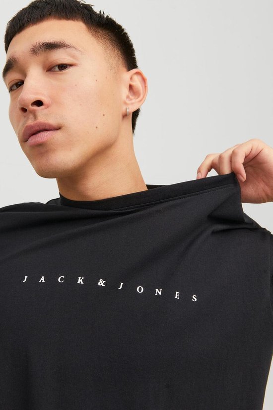 Model draagt een zwarte Jack & Jones t-shirt met witte tekst.