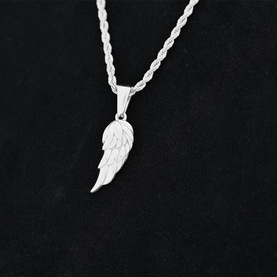 Een zilverkleurige ketting met een vleugelpendant, gedragen op een zwart kledingstuk.